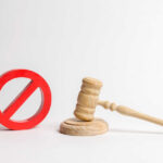 Wooden judge's gavel beside a red prohibition symbol