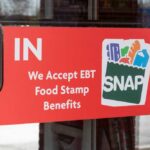 SNAP Cliff Looms – Work Or Lose Aid Sign on a store door indicating acceptance of EBT food stamp benefits
