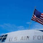 U.S. Air Force plane with American flag against sky.