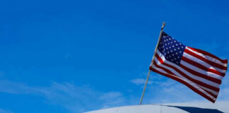 U.S. Air Force plane with American flag against sky.