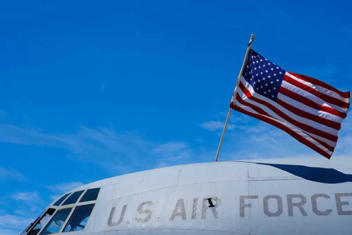 U.S. Air Force plane with American flag against sky.