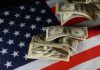 Election Bribe? Trump Teases $5K Payout Dollar bills arranged on an American flag