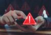 Person using smartphone with red warning icons overlay