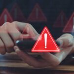 Person using smartphone with red warning icons overlay