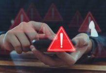 PRIVACY ALERT: Surveillance Net Tightens In Capitol City Person using smartphone with red warning icons overlay