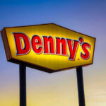 Denny’s Announcement Impacts 500 Locations Dennys sign illuminated against a twilight sky