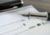 Close-up of a fountain pen poised over a blank check