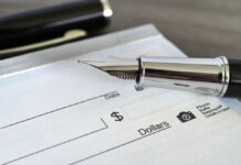 Paycheck Ambush Coming in 2027 Close-up of a fountain pen poised over a blank check