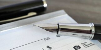 Close-up of a fountain pen poised over a blank check