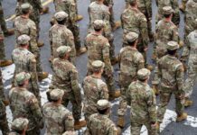 Timmy Jernigan among soldiers marching in formation on a street