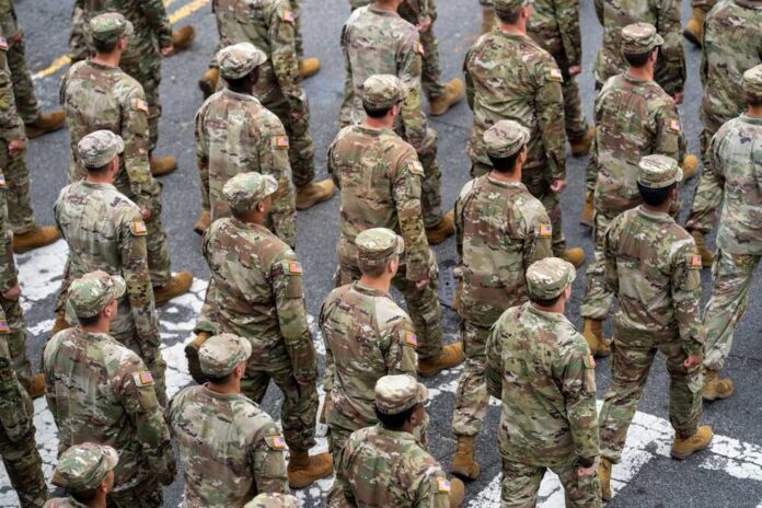 Timmy Jernigan among soldiers marching in formation on a street