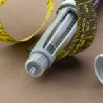 GLP-1 Wave Slams Fast Food Insulin pen with needle and yellow measuring tape