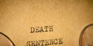 Typewriter typing the words death sentence on paper