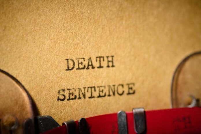 Typewriter typing the words death sentence on paper