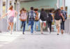 Pay Soars, Buses Still Empty – WHY? Children running with backpacks outside a school building.