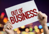 NEW: 25 Stores Axed Hands holding an out of business sign