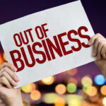 NEW: 25 Stores Axed Hands holding an out of business sign