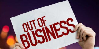 Hands holding an out of business sign