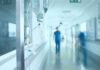 Hospital corridor with IV drip and healthcare worker.