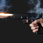Cross-Country Hit? Superstar Singer Targeted A hand holding a gun with smoke and a flash from the muzzle