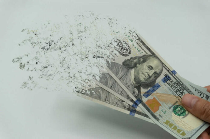 Hundred-dollar bills disintegrating in hand.
