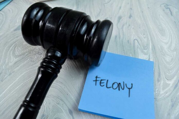 Concept,Of,Felony,Write,On,Sticky,Notes,With,Gavel,Isolated Judge's gavel resting on a blue sticky note
