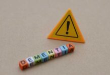 Raspy Voice Tied To Dementia? Colorful letter blocks spelling 'DEMENTIA' next to a warning sign