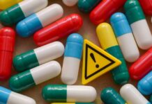 Deadly Gas-Station Pills Exposed Colorful capsules scattered around a yellow warning sign