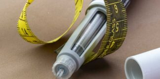 Insulin pen with needle and yellow measuring tape